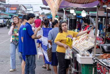 Suratthani, Tayland - 21 Nisan 2024: Yemek ve sebze almak için sokaklarda yürüyen insanlar, hem Tayland 'ın şehir ve kırsal kesimlerinde hem de sokak yemeklerinde yol kenarında satılıyor.
