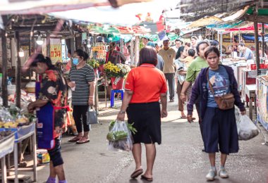 Suratthani, Tayland - 24 Nisan 2024: Hem Tayland 'ın kırsal kesimlerinde, hem de Tayland' ın kırsal kesimlerinde satılan içecek, yiyecek ve sebze almak için sokaklarda yürüyen insanlar
