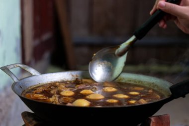 Sıcak bir ocağın üzerine, kaynayan ve bulanık arka plana yerleştirilmiş yumurta buğulama.