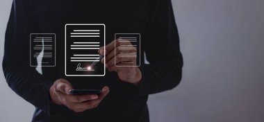 Çevrimiçi iş sözleşmesi, elektronik imza, dijital belgeler, sözleşmeli sözleşme imzalama, genç adam internet üzerinden iş sözleşmesi imzalamak için akıllı telefon kullanıyor.