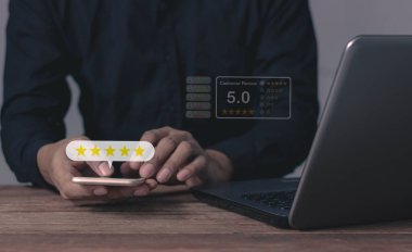 Memnuniyet Değerlendirmesi, Genç Adam akıllı telefon ve dizüstü bilgisayara dokunarak değerlendirmek için beş yıldız veriyor ve çok iyi sonuçlar veren 5 yıldız veriyor.