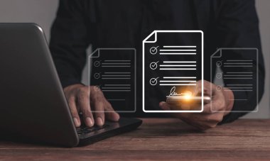 Bilgisayarlı genç adam internet üzerinden iş sözleşmesi imzalamak için akıllı telefonlu cep telefonuna dokunuyor. Elektronik imza, dijital belgeler, gelecekteki iş sözleşmesi imzası.
