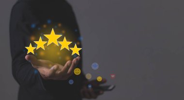Müşteri memnuniyeti, akıllı telefonlu genç adam değerlendirmek için beş yıldız tutuyor ve çok iyi sonuçlar veren 5 yıldız veriyor.