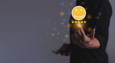 Mutlu Müşteri, genç adam akıllı cep telefonu kullanıyor emoji 'ye dokunarak beş yıldızlı inceleme yapıyor ve 5 yıldıza çok iyi sonuçlar veriyor, 5 yıldızlı geri bildirim iyi