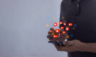 Genç adam el ele tutuşuyor, Sevgi, Takip ve Yorum Simgesi ile akıllı telefon cep telefonu kullanıyor.