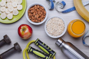 Sağlıklı yiyecekler. Meyveler, bademler, yulaf ezmesi, beyaz bir masada portakal suyu. Fitness. Düz üst görünüm