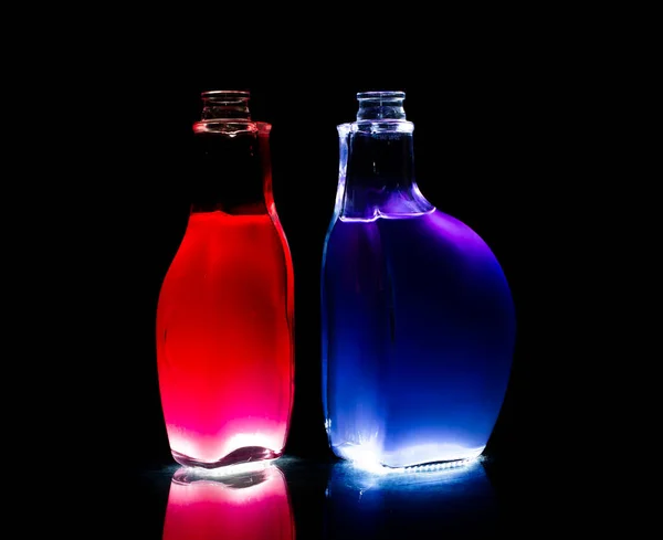Beleuchtete Gläser Auf Schwarzem Hintergrund Flaschen Mit Farbiger Flüssigkeit Inneren — Stockfoto