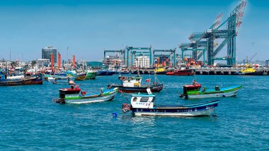 Balıkçı tekneleri ve endüstriyel vinçlerle dolu liman