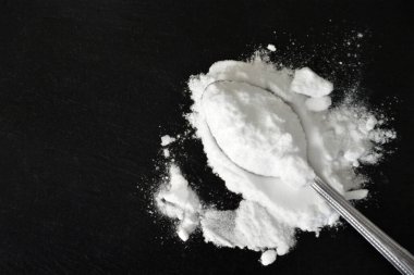 Fotokopi alanı ile siyah zemin üzerinde kabartma tozu kaşık düz yatıyordu 