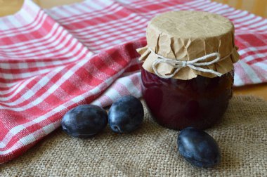 Ahşap arka planda kavanozda ev yapımı erik reçeli