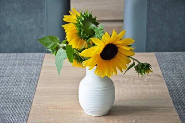 Sunflowers in vase on the table. Autumn festive decoration.