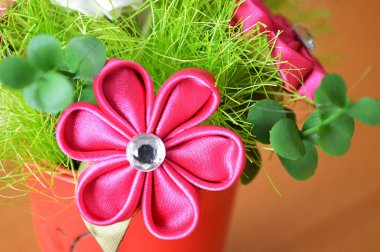 El yapımı pembe kumaş çiçeği (kanzashi). Yapay çiçek süslemesi. Hobi ve zanaat konsepti.