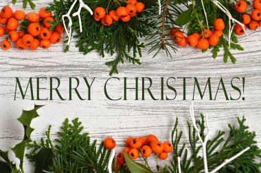 Ağaç zemin üzerinde ağaç dalları ve portakal meyvelerinden oluşan noel çelengi, düz bir zemin. Mutlu Noeller kartı.