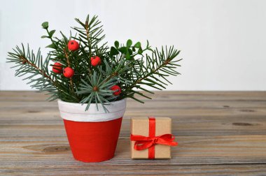 Mutlu noel kartı şablonu. Kırmızı bereli ve küçük ambalajlı çam dalları. 