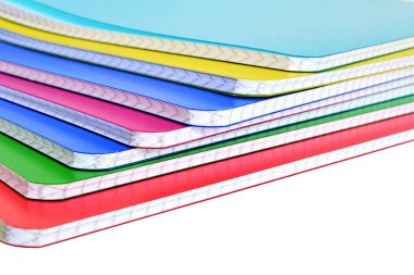 Beyaz arkaplan üzerine renkli kitapların yığını