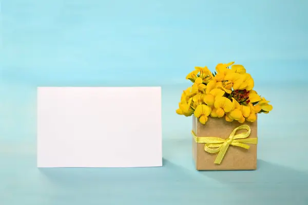Empty greeting card and yellow flowers