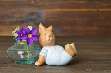 Paskalya tavşanı ve vazodaki çiçekler ahşap arka planda, boşluğu kopyala