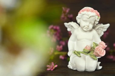 Koruyucu melek bir demet gül tutuyor 