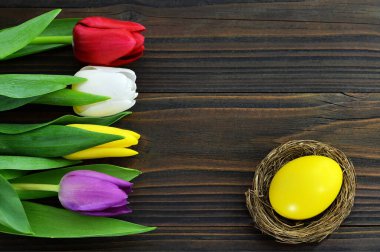 Paskalya kartı: Yuvadaki Paskalya yumurtası ve parlak laleler