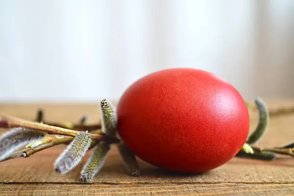 Stock image Red Easter egg and willow branch on wooden table 