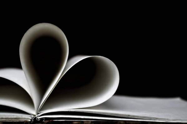 heart shape pages on book over black background
