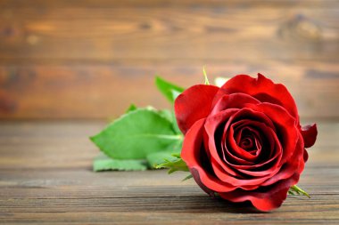 Ahşap arka planda kırmızı gül olan Sevgililer Günü kartı
