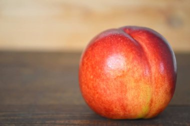 Tahta zemin üzerinde olgun kırmızı nektarin.