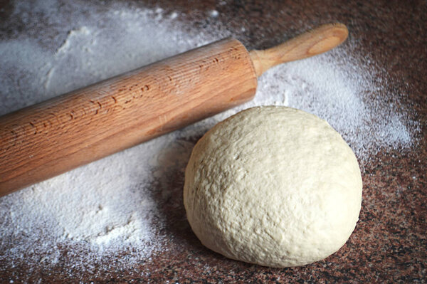 Raw dough with rolling pin