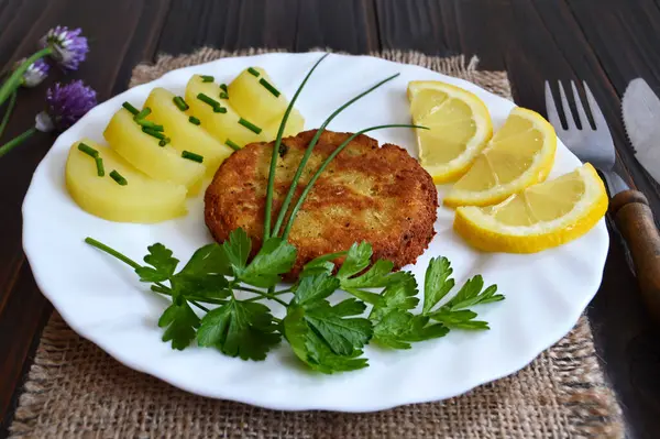 Balık köftesi, patates salatası ve limon dilimleri.