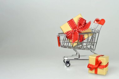 Beyaz arka planda alışveriş arabasında hediye kutusu 