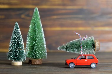 Oyuncak arabalı Noel kartı. Ahşap arka planda Noel ağacı var. 