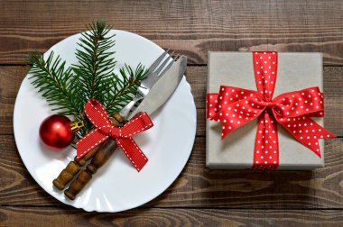 Süslü Noel tabağı ve tahta arka planda hediye kutusu.