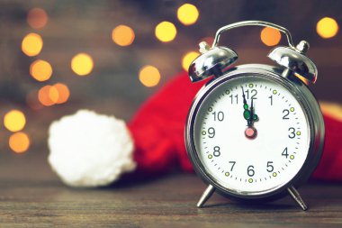 Mutlu noeller ve mutlu yeni yıl konsept kartı çalar saat ve Noel Baba şapkası 