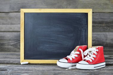 Kırmızı spor ayakkabılı boş tebeşir tahtası.