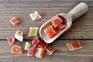 Ahşap arka planda ahşap kepçe içinde kurutulmuş mango.