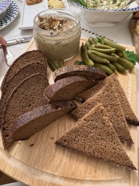 A slice of rye bread with crunchy gherkins and creamy liver pt. This savory dish brings together rich flavors and textures, perfect for a traditional and hearty snack or appetizer, showcasing rustic, homemade goodness. clipart