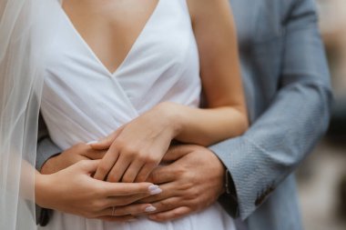 Gelin ve damat nazikçe el ele tutuşuyorlar.