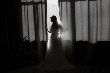 portrait of a bride girl with red hair in a white wedding dress with a bouquet