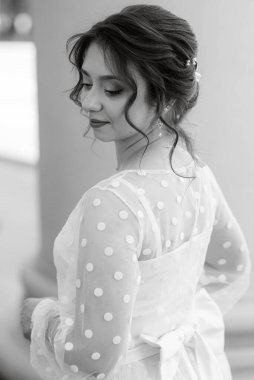 portrait of a young bride girl in a light dress walks in an urban environment