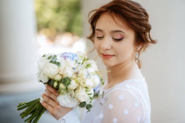 portrait of a young bride girl in a light dress walks in an urban environment