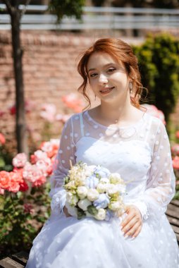 portrait of a young bride girl in a light dress walks in an urban environment