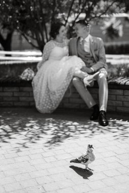 bride in a light wedding dress with a bouquet next to the groom in a blue suit