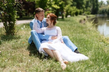 bride in a light wedding dress with a bouquet next to the groom in a blue suit