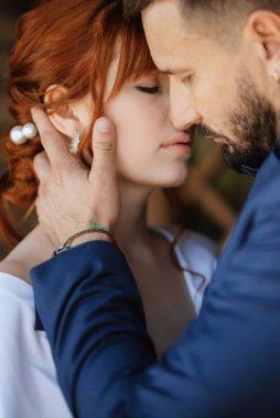 bride in a white dress with a bouquet and the groom in a blue suit on their wedding day