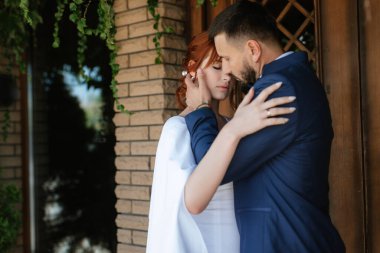 bride in a white dress with a bouquet and the groom in a blue suit on their wedding day