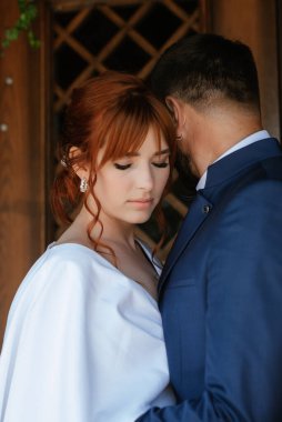 bride in a white dress with a bouquet and the groom in a blue suit on their wedding day