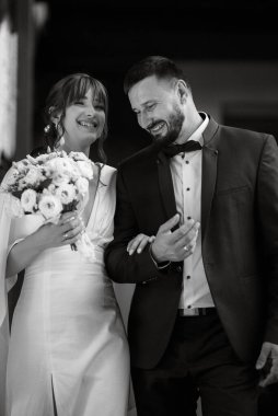 bride in a white dress with a bouquet and the groom in a blue suit on their wedding day