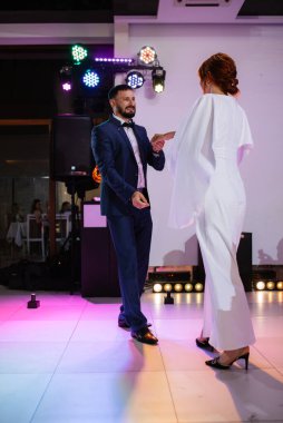 Gelin ve damadın ilk düğün dansı gün batımında restoranın içinde.