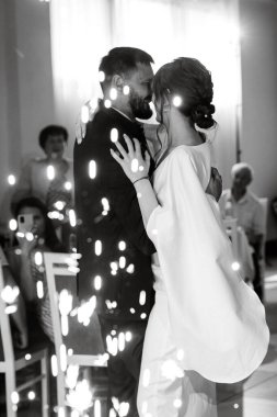 Gelin ve damadın ilk düğün dansı gün batımında restoranın içinde.