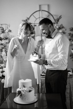 newlyweds happily cut, laugh and taste the wedding cake